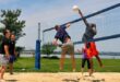 Mehrere Spieler und Spielerinnen beim Beachvolleyball.